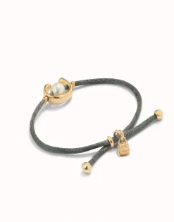 Pulsera de hilo negroso con perla shell fornitura bañada en oro 18k.